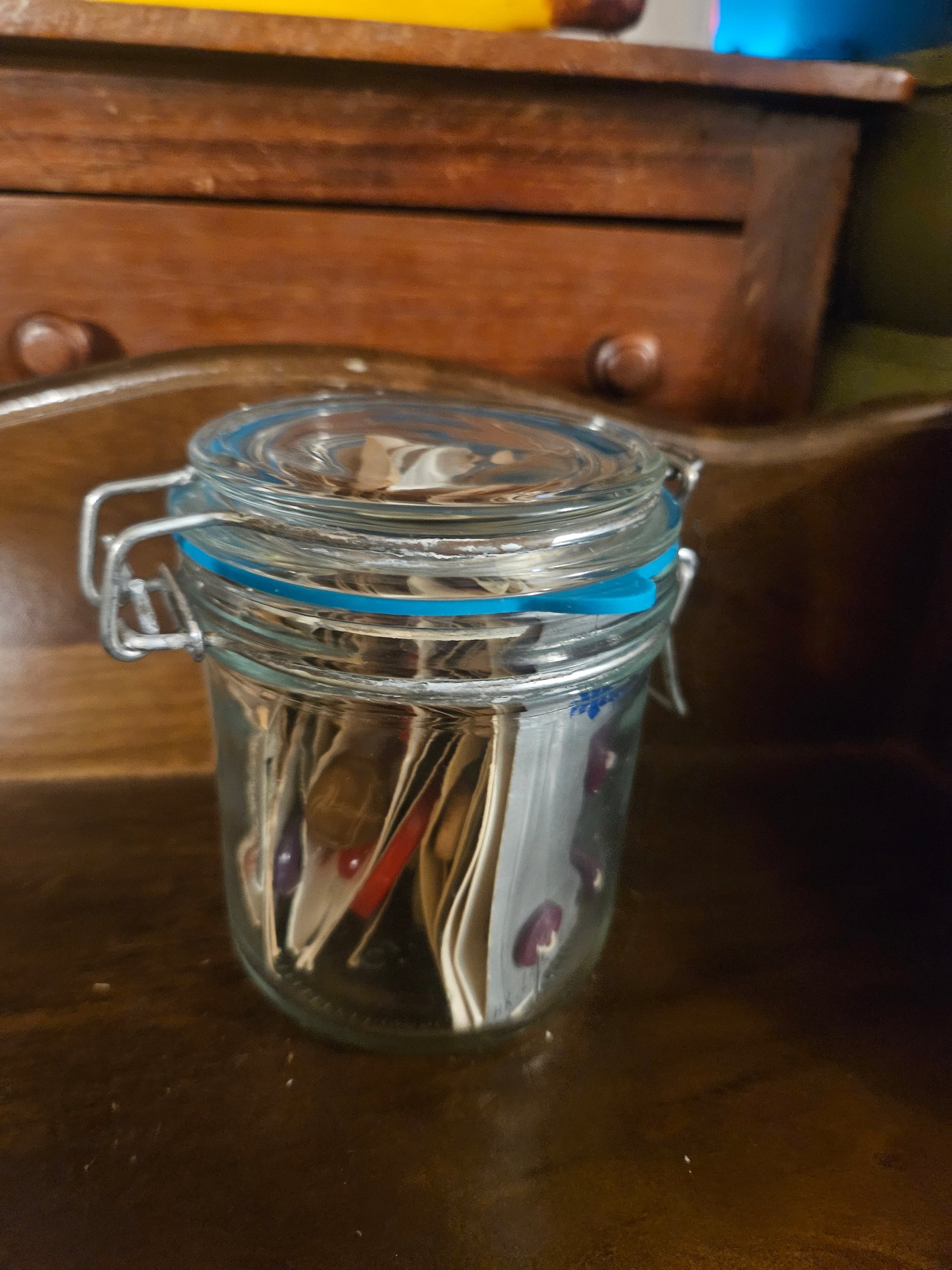 Swing-top glass jar filled with vintage button cards, closed view