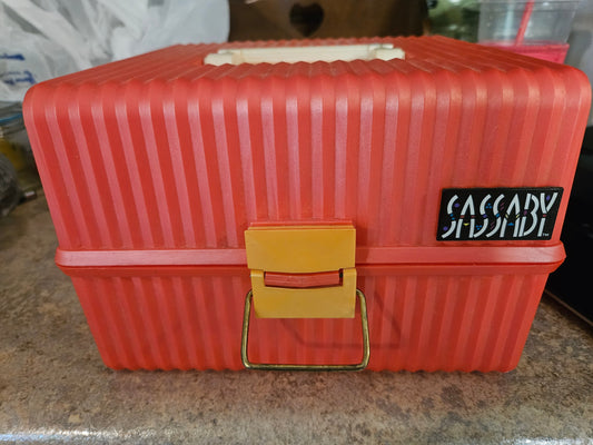 Vintage Sassaby red makeup train case front view showing yellow latch and Sassaby logo
