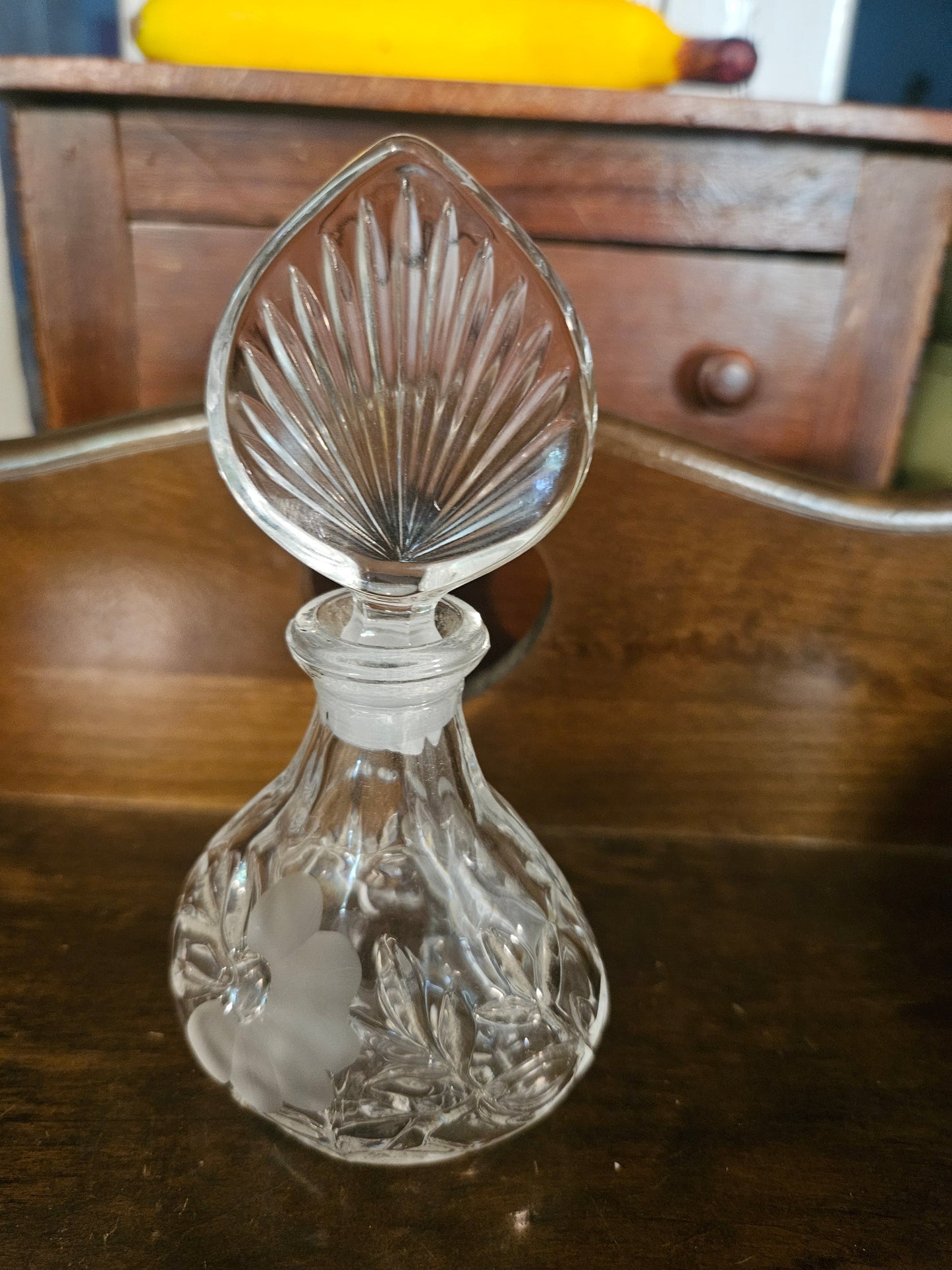Side view of cut crystal perfume bottle showing frosted grape and leaf etching